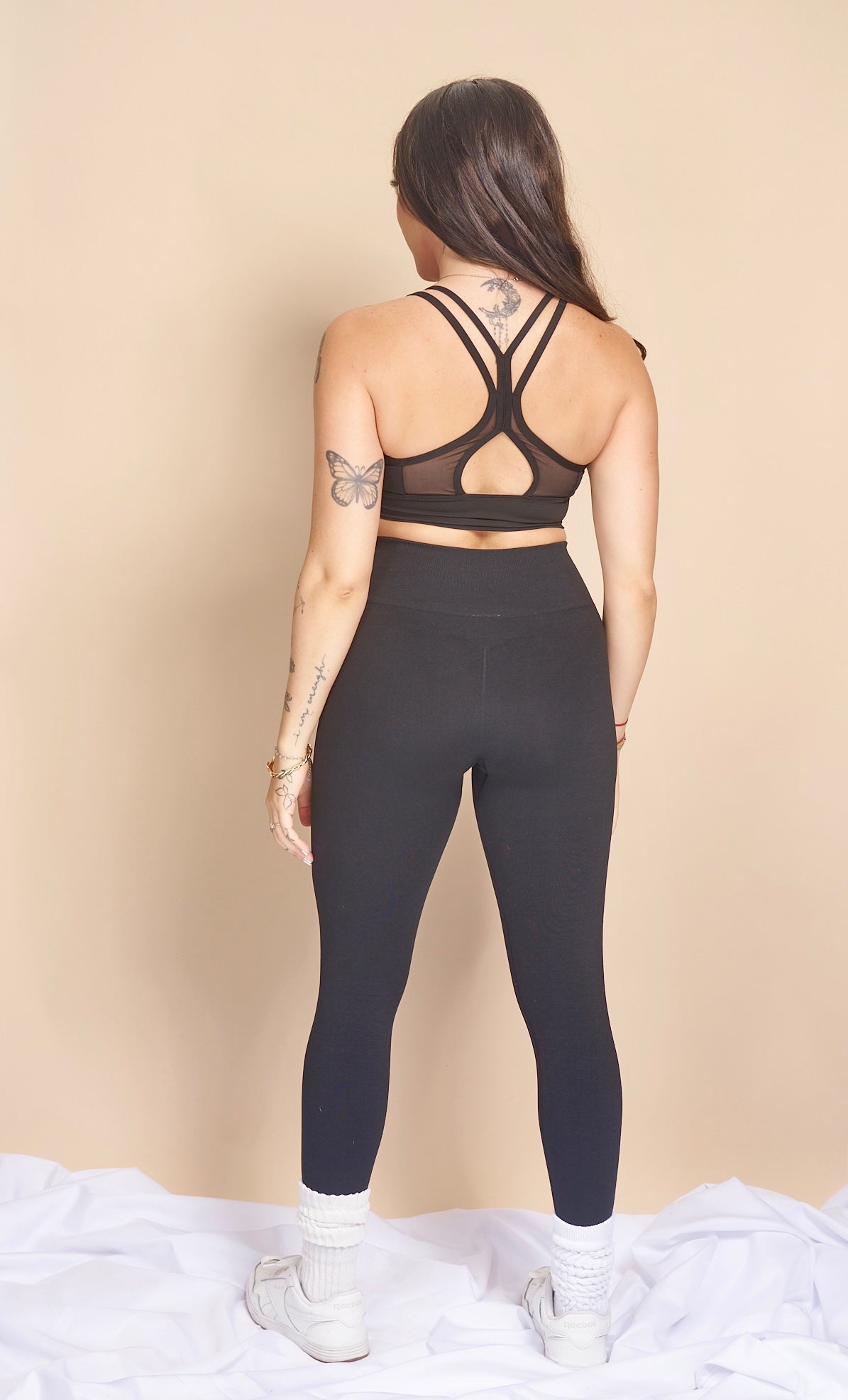 Model 1 showing the back of kiki's crew black sports bra size small