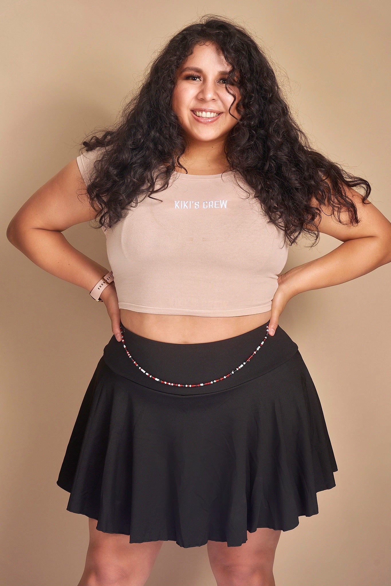 Model 2 wearing size large kiki's crew t-shirt along with size extra large tennis skort