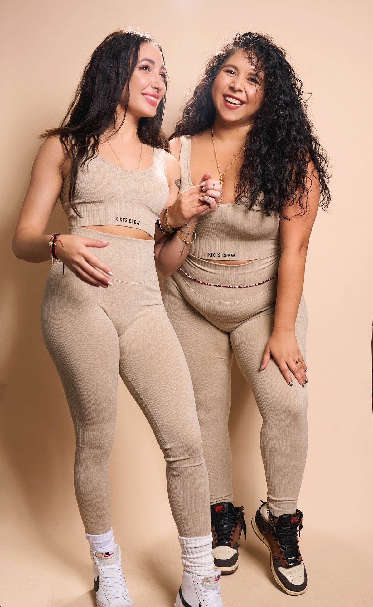 Model 1 and 2 together wearing the kiki's crew matching sports top and leggings, color beige, size small and size large