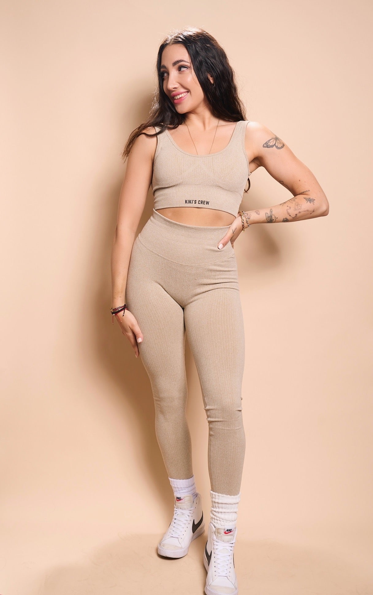 Model 1 wearing size small of the kiki's crew matching sports top and leggings, color beige