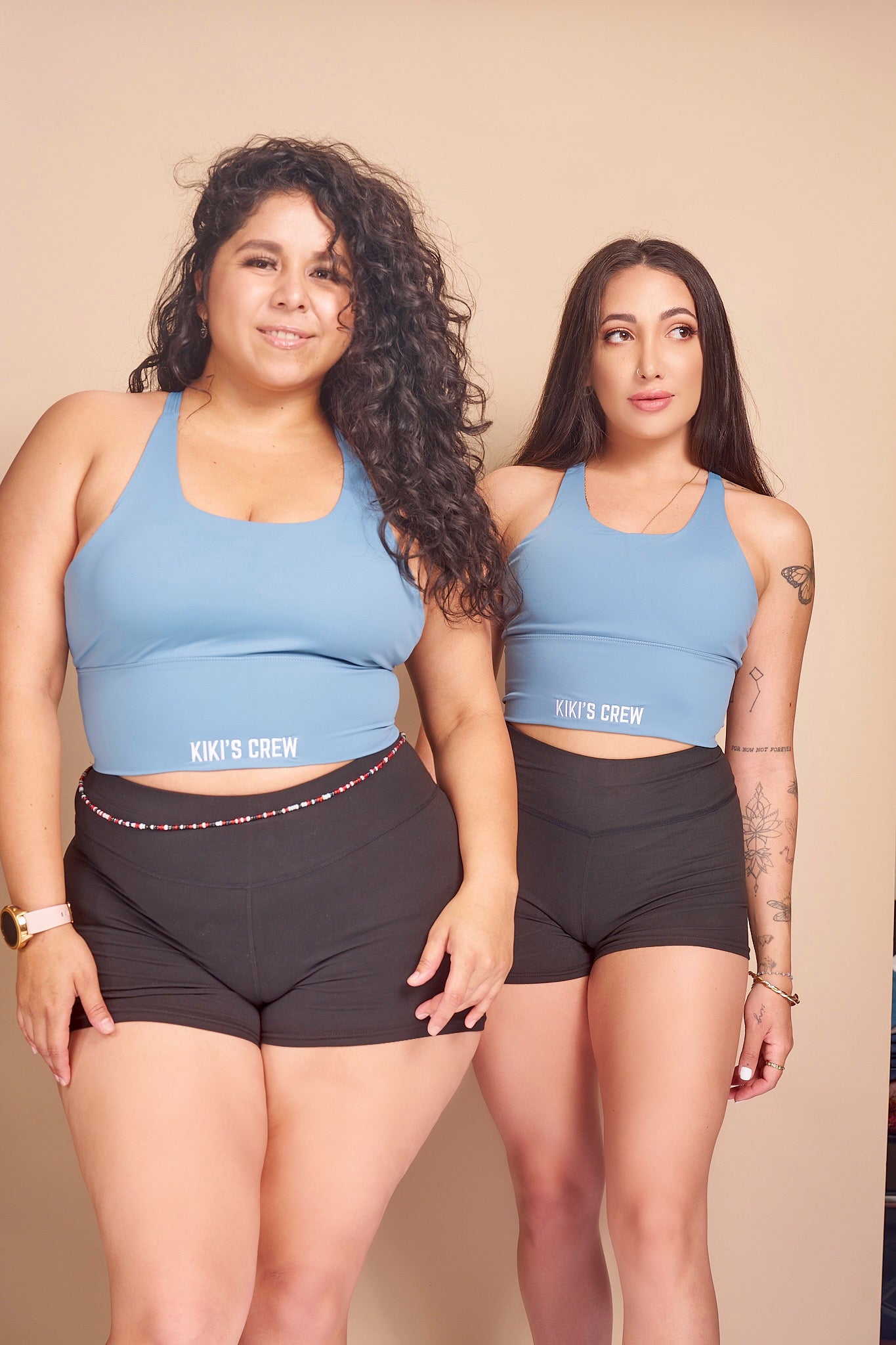 Model 1 wears a size small and Model 2 wears a size large of Kiki's crew baby blue sports tank top along with Kiki's crew basic spandex shorts