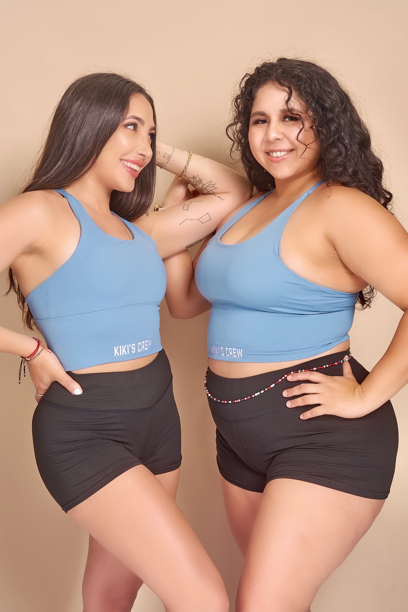 Model 1 wears a size small and Model 2 wears a size large of Kiki's crew baby blue sports tank top along with Kiki's crew basic spandex shorts