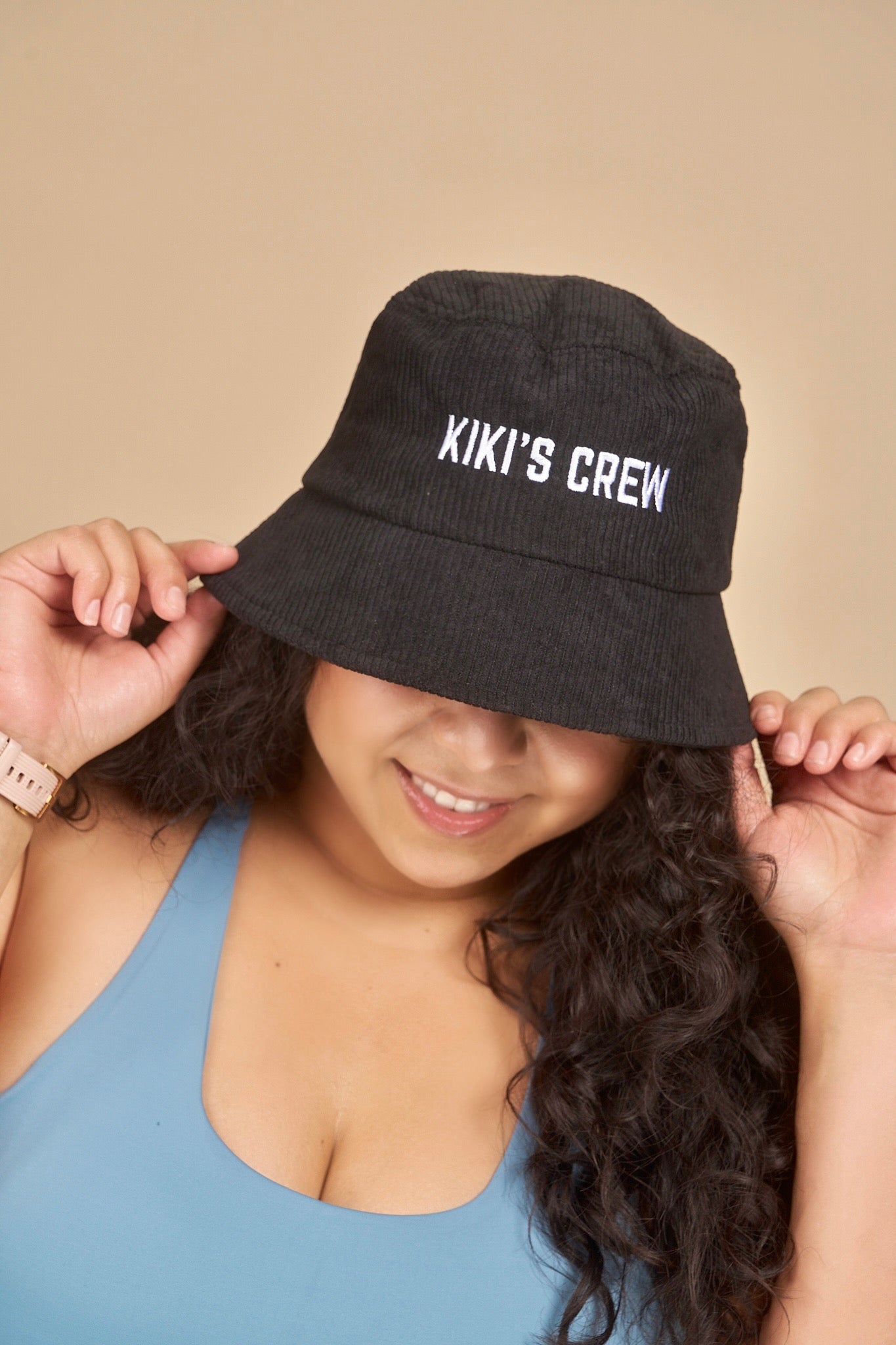 Model 2, female, wearing kiki's crew black corduroy bucket hat 