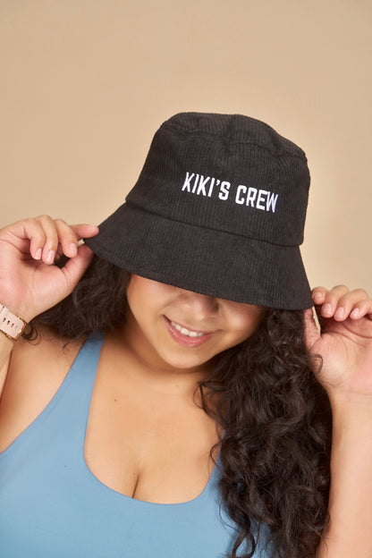 Model 2, female, wearing kiki's crew black corduroy bucket hat 