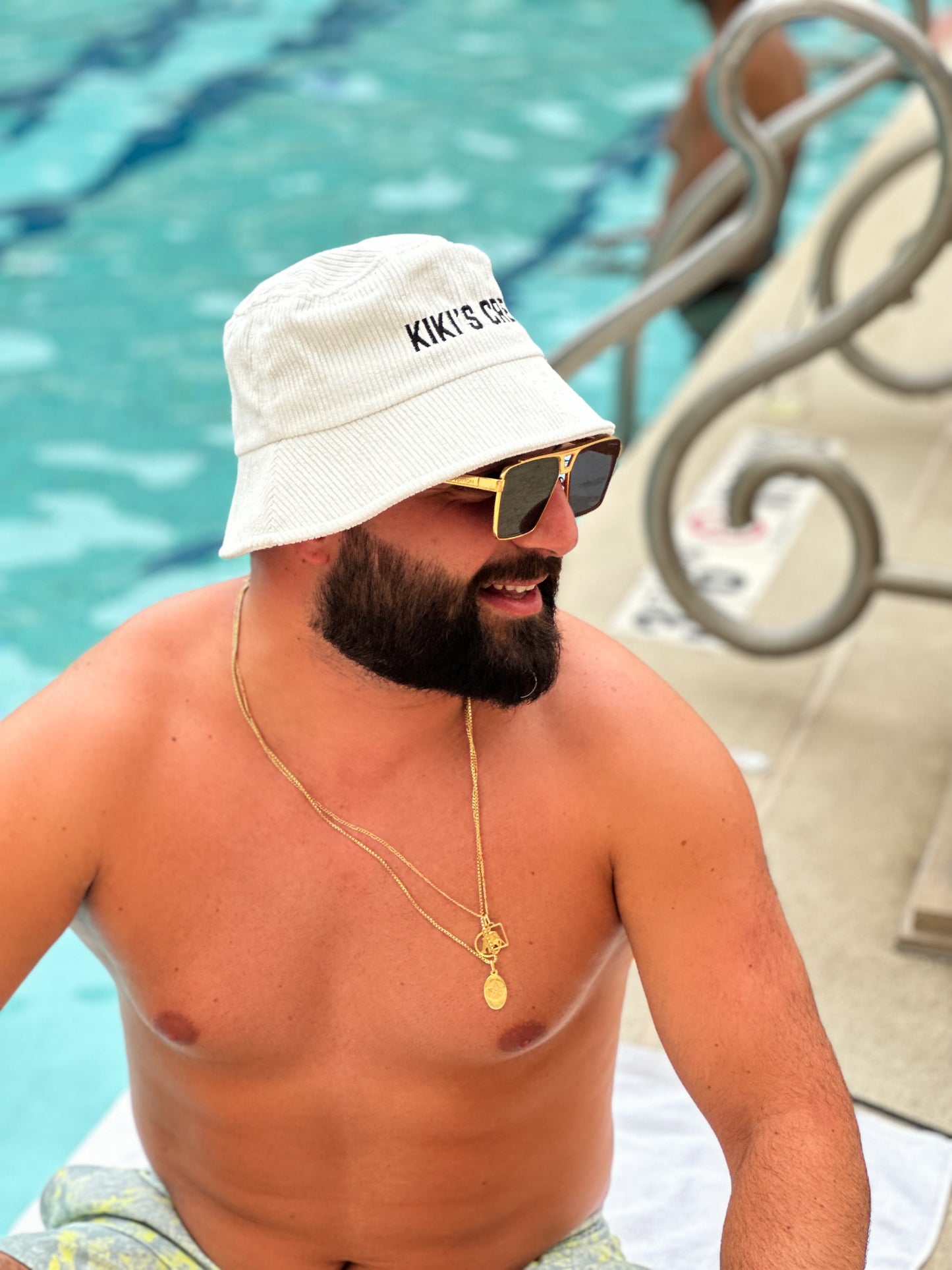 Model 3, male, wearing kiki's crew white corduroy bucket hat at the pool 