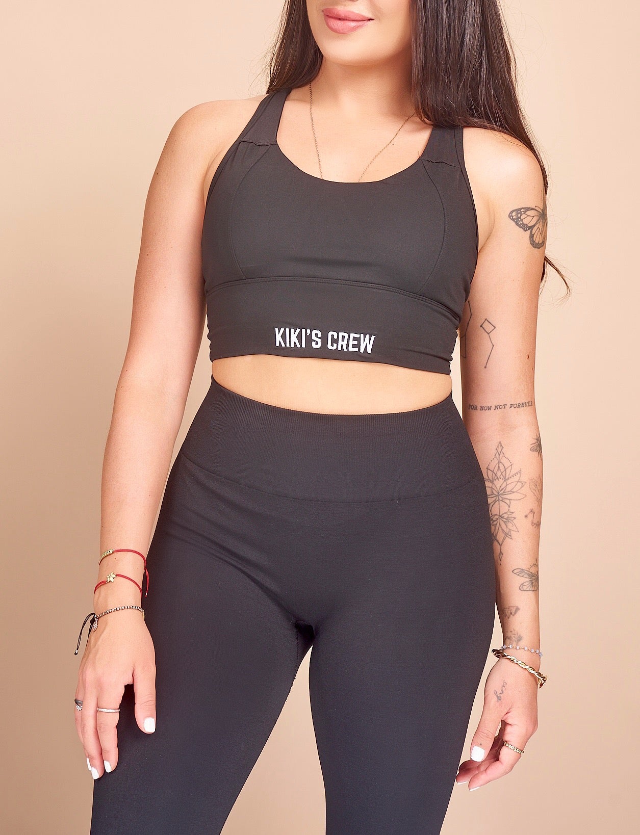 Model 1 wearing size small of kiki's crew black sports bra